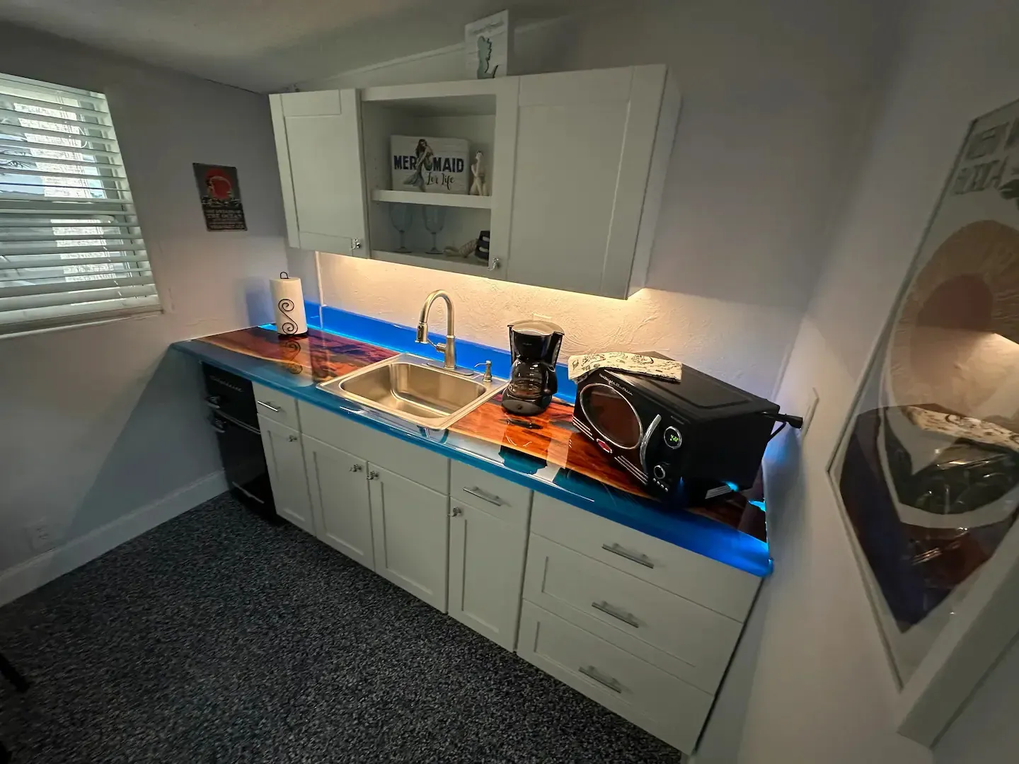 A kitchen with a sink , dishwasher , coffee maker and microwave.