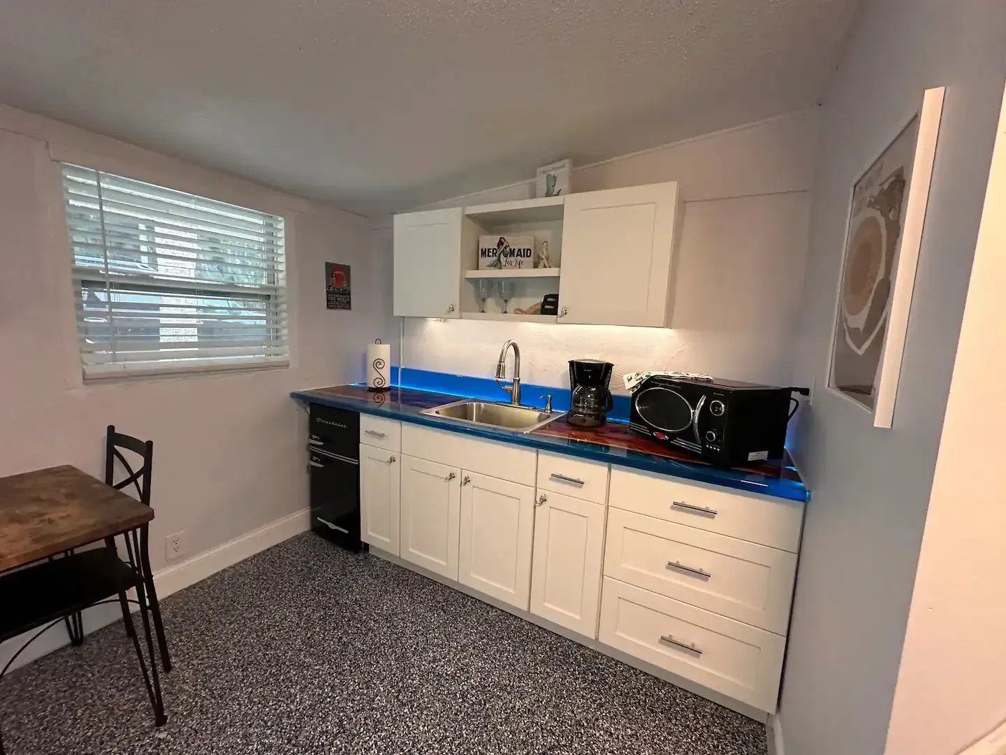 A kitchen with a sink , microwave , and dishwasher.