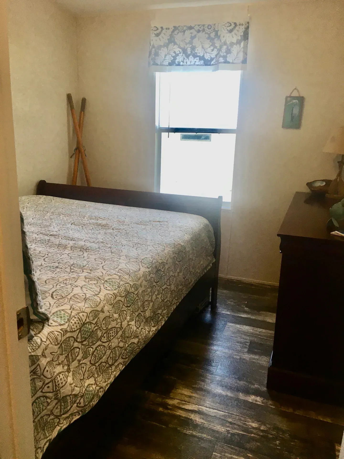 A bedroom with a bed , dresser and window