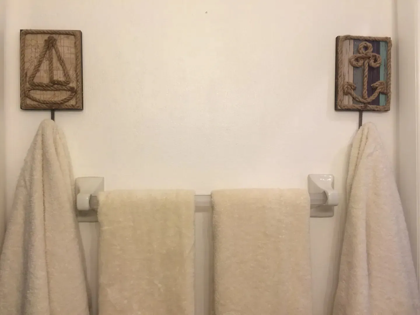 Two towels are hanging on a towel rack in a bathroom.