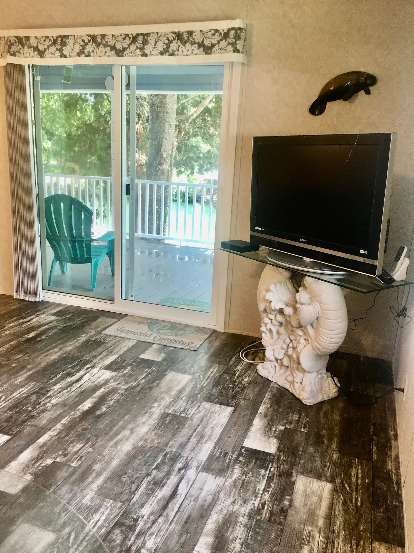 A living room with a sliding glass door and a flat screen tv.
