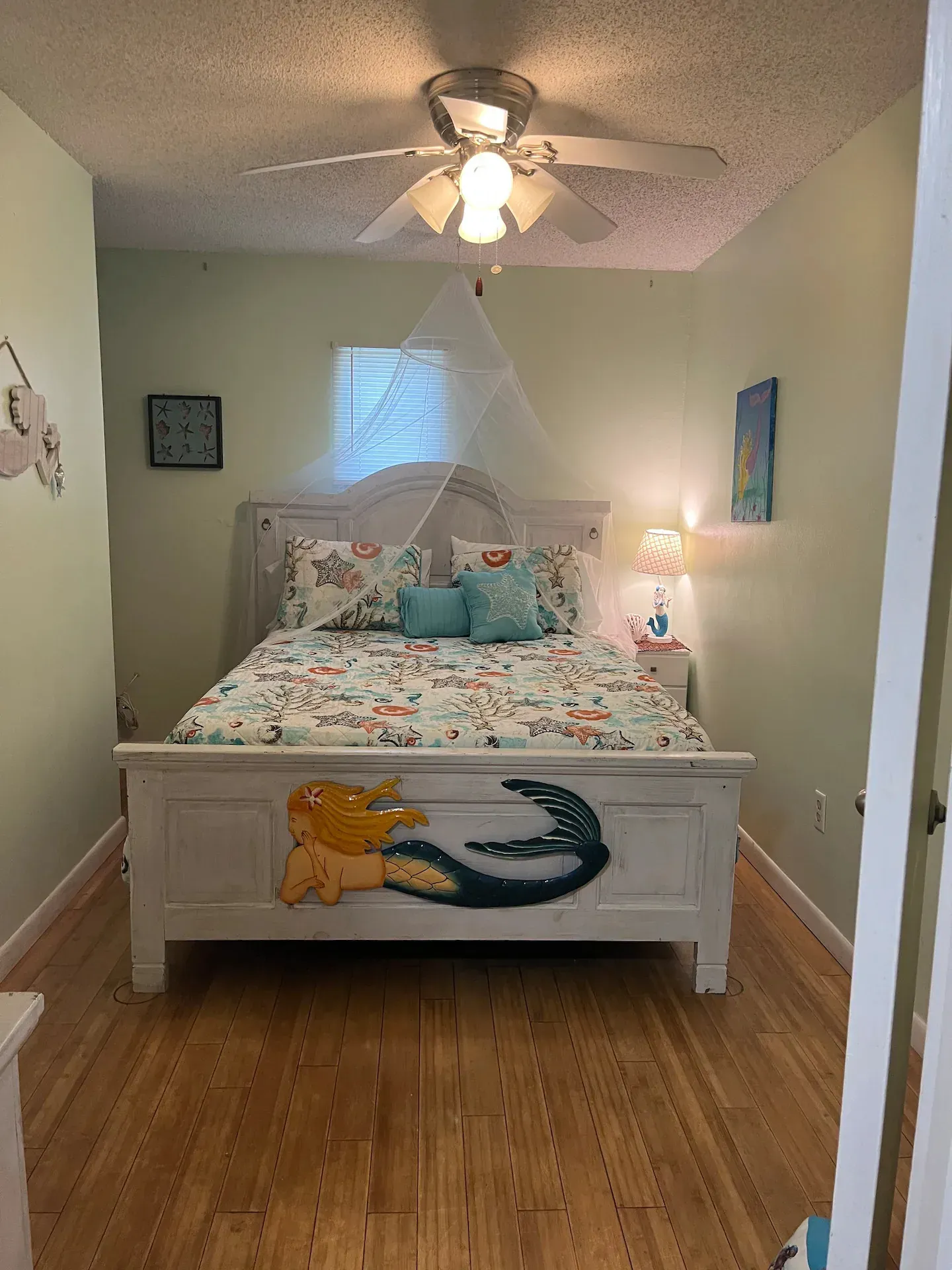 A bedroom with a bed and a ceiling fan.