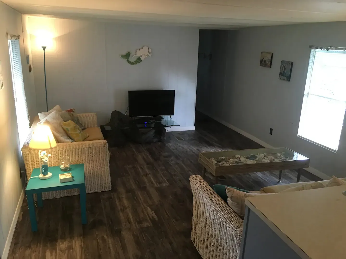 A living room with a couch , chair , table and television.