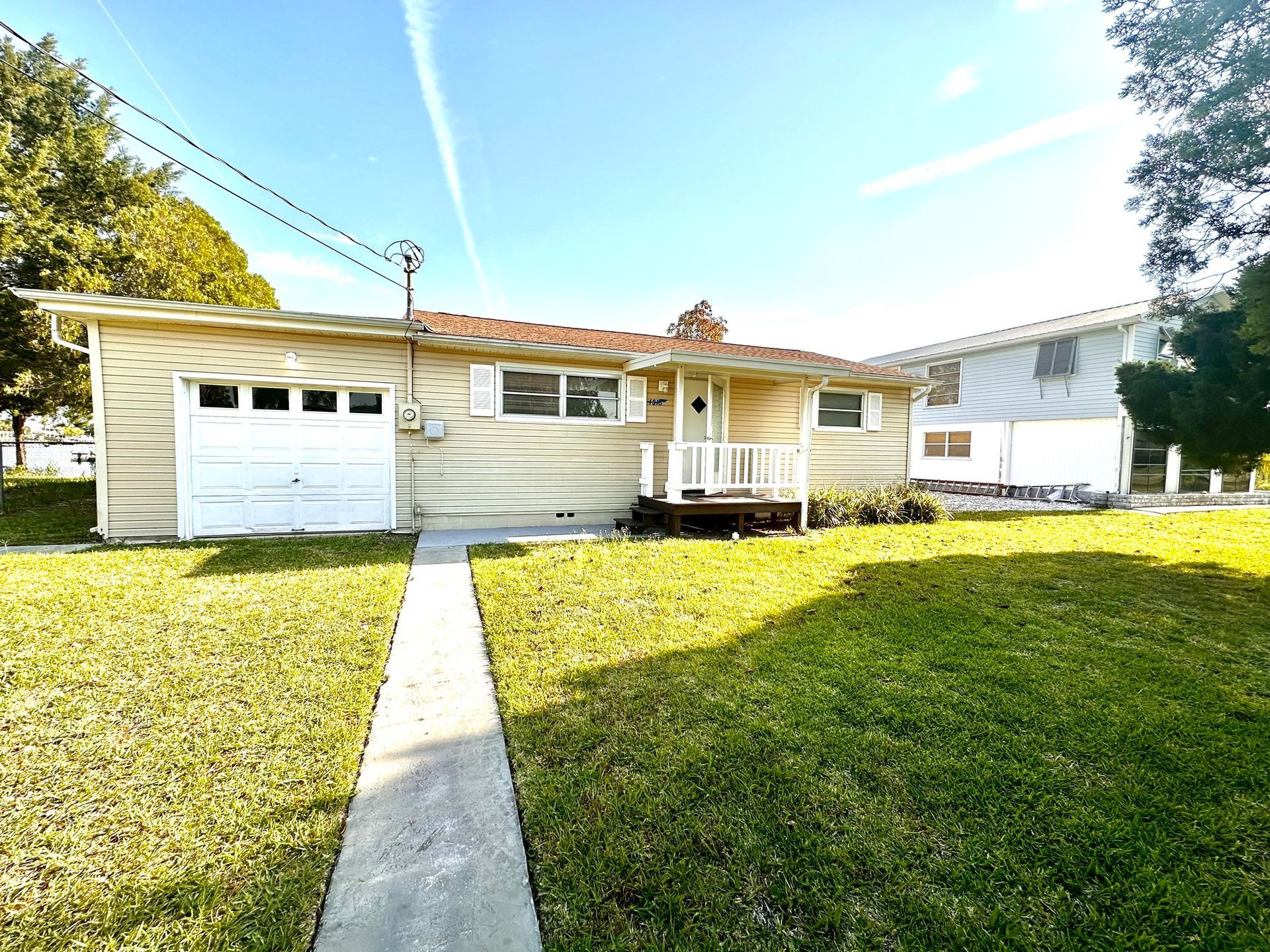A house with a garage and a walkway leading to it.
