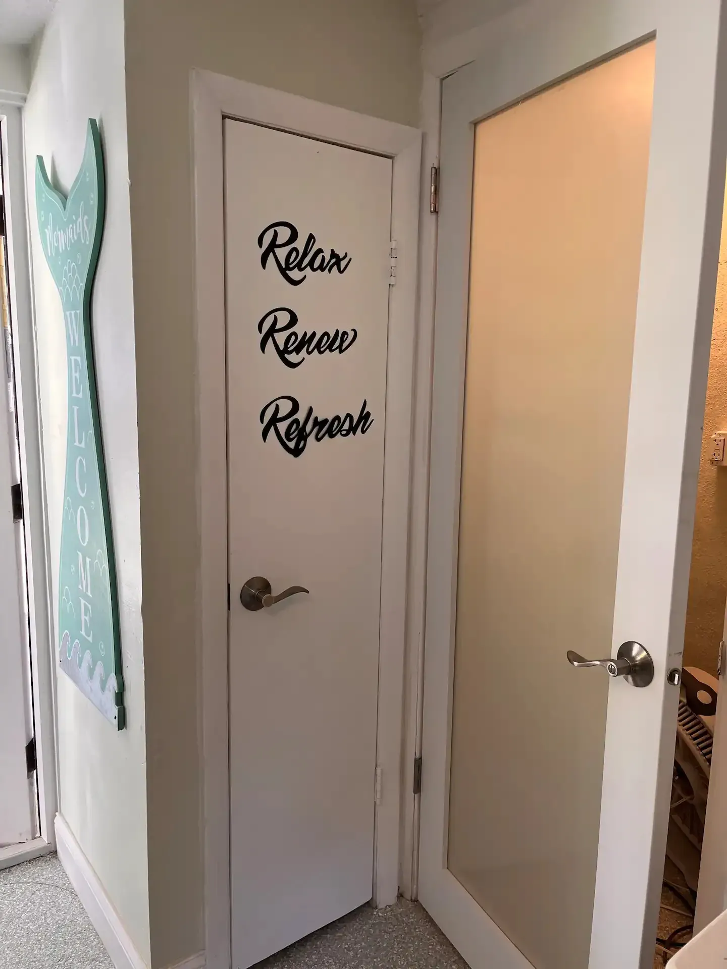 A white door with a sign on it that says `` relax renew refresh ''.