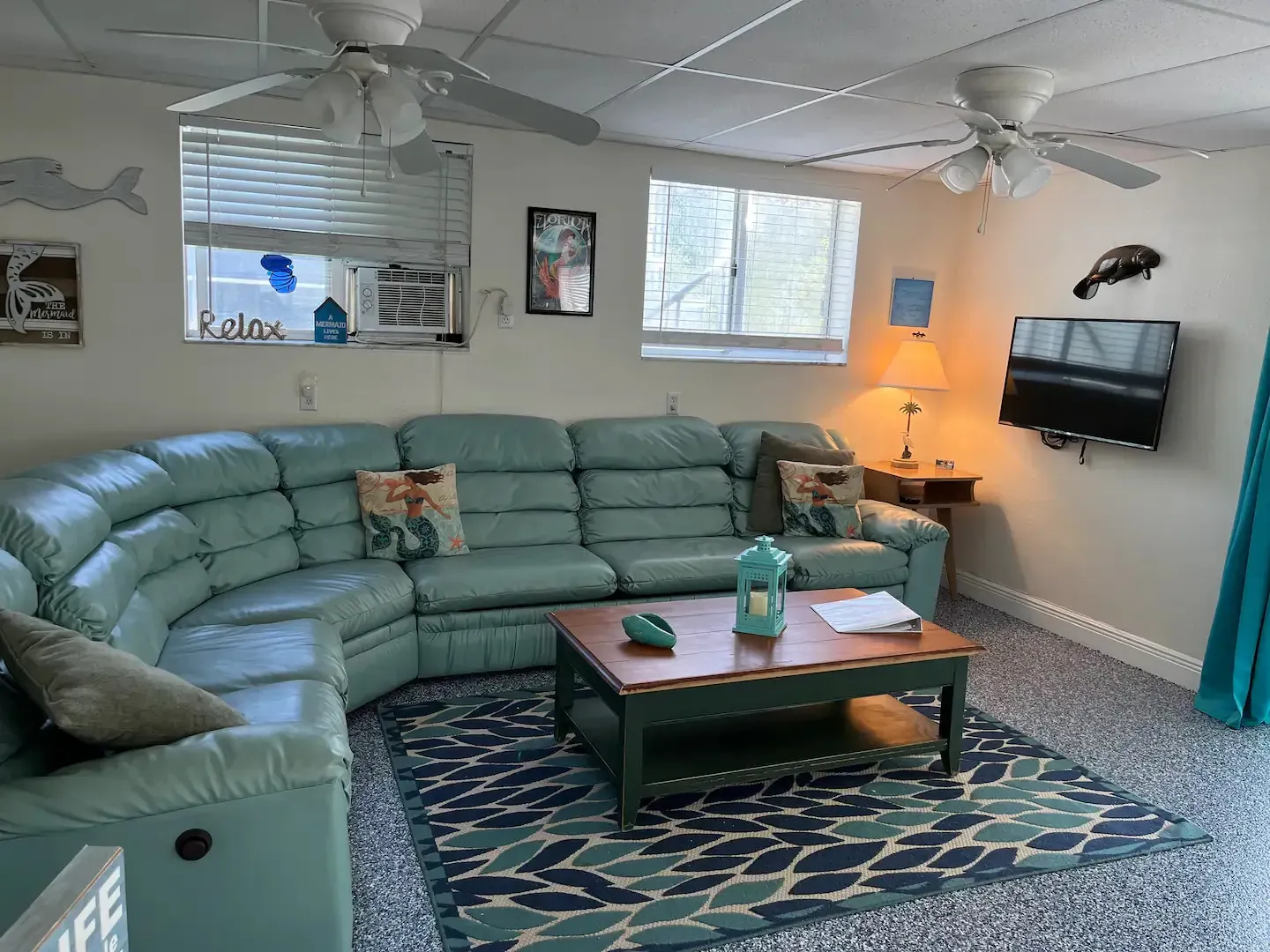 A living room with a couch , coffee table , and television.