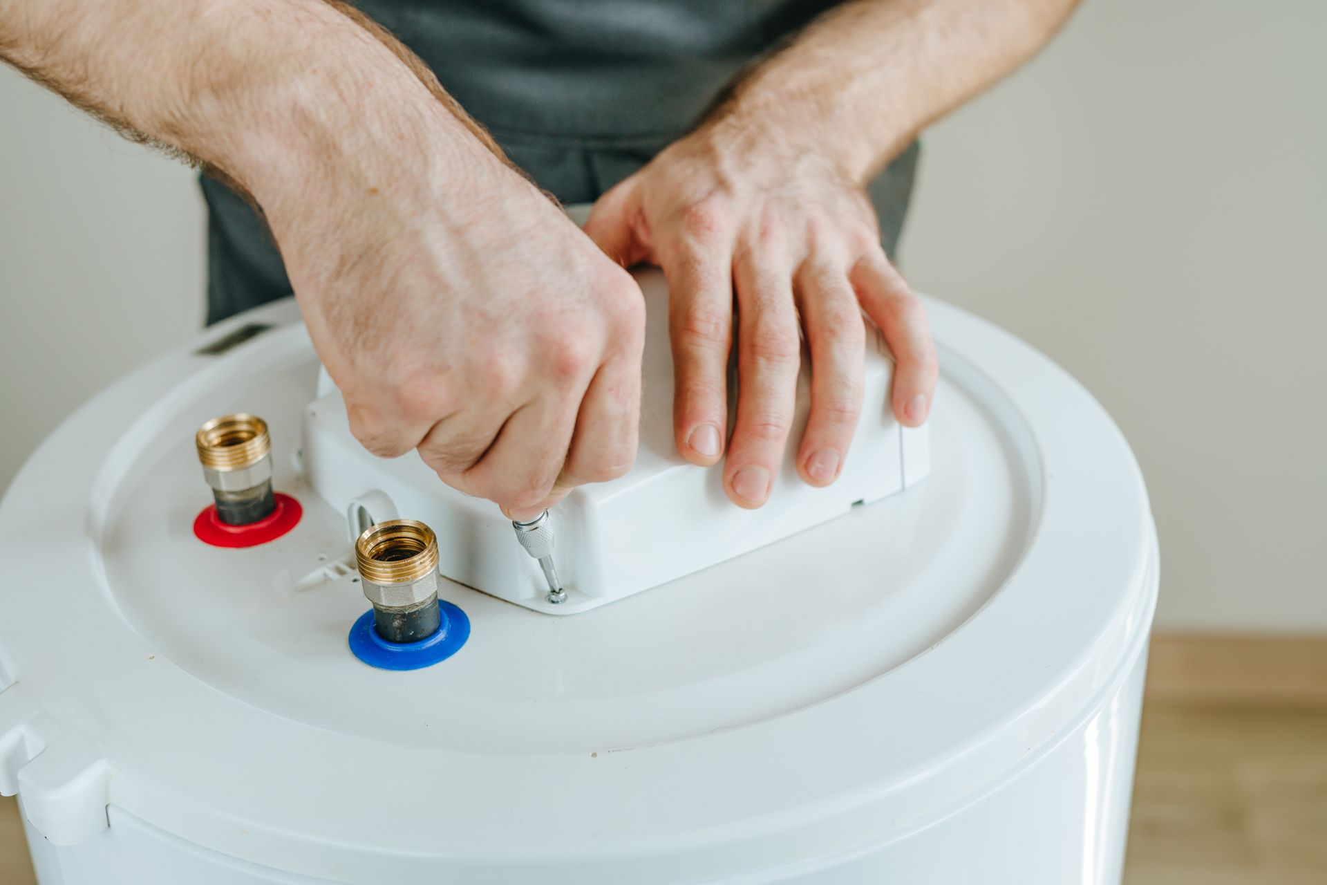 Close-up of technician mounting a control module on a home water heater.