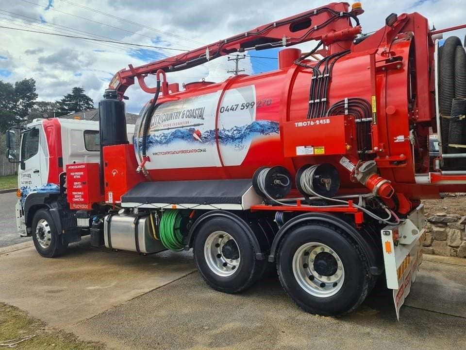 A red and white vacuum truck is parked on the side of the road — Hydro Excavation in Goulburn, NSW