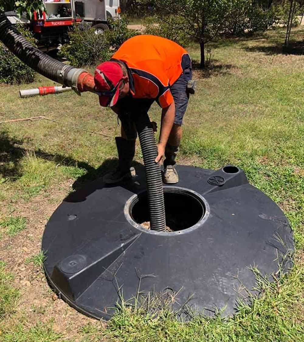 A man is cleaning a septic tank — Hydro Excavation in Goulburn, NSW