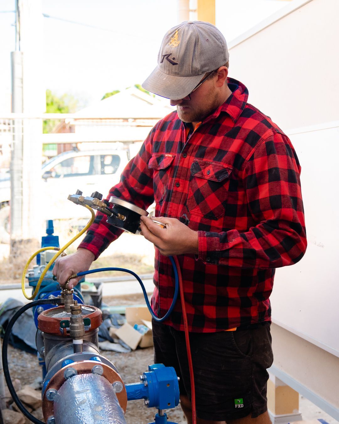 Man Kneeling Down Fixing Plumbing Pipes — Hydro Excavation in Goulburn, NSW