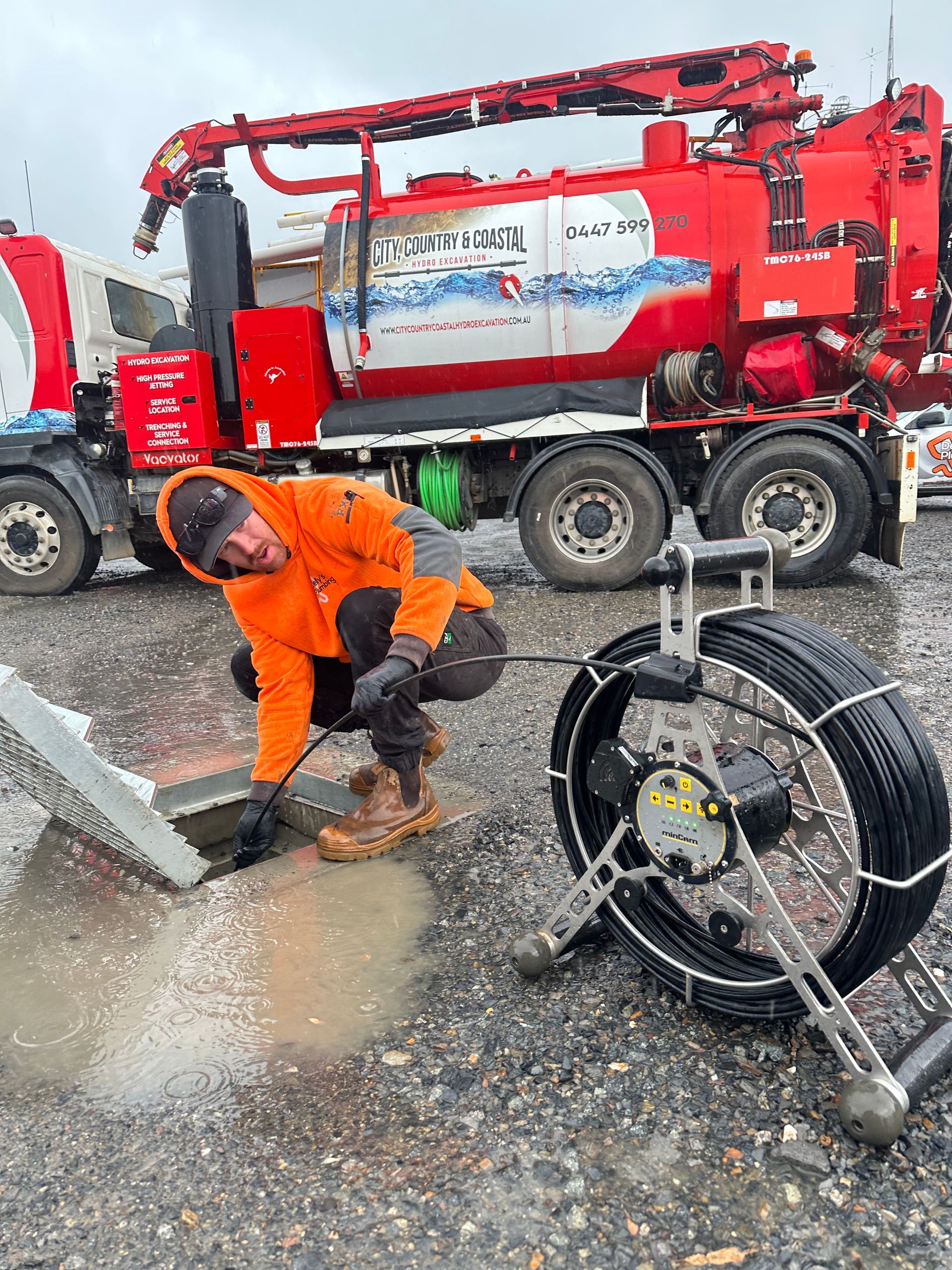 A man with a camera going down a sewer for pipe camera inspection — Hydro Excavation in Goulburn, NSW