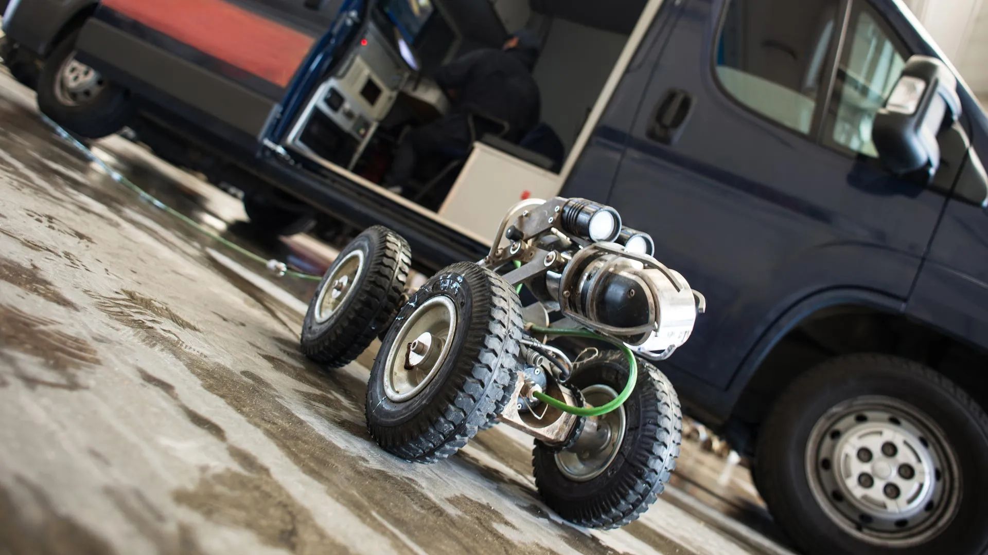 A Robot Is Sitting Next To A Van In A Parking Lot — Hydro Excavation in Goulburn, NSW