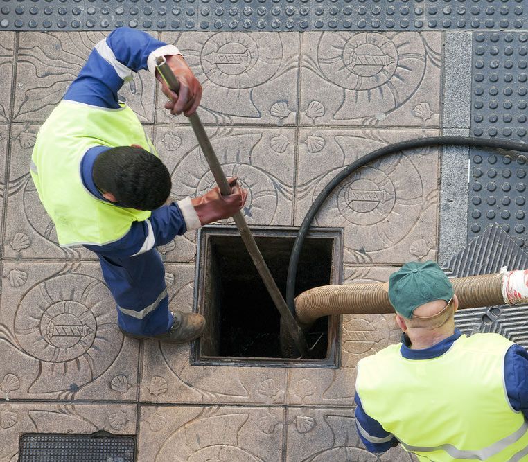 Workers Moves The Manhole Cover To Cleaning The Sewer Line For Clogs — Hydro Excavation in Goulburn, NSW