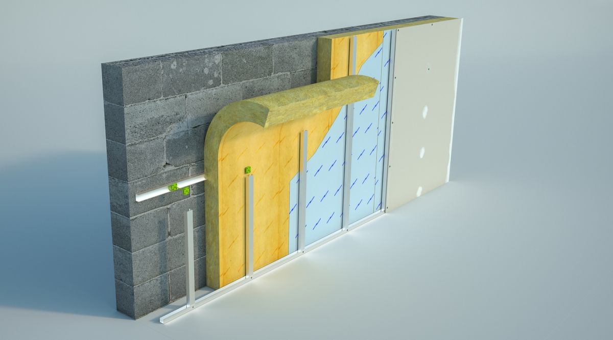Section de mur isolé avec briques grises, conduits jaunes et panneaux bleus dans un schéma en coupe 3D
