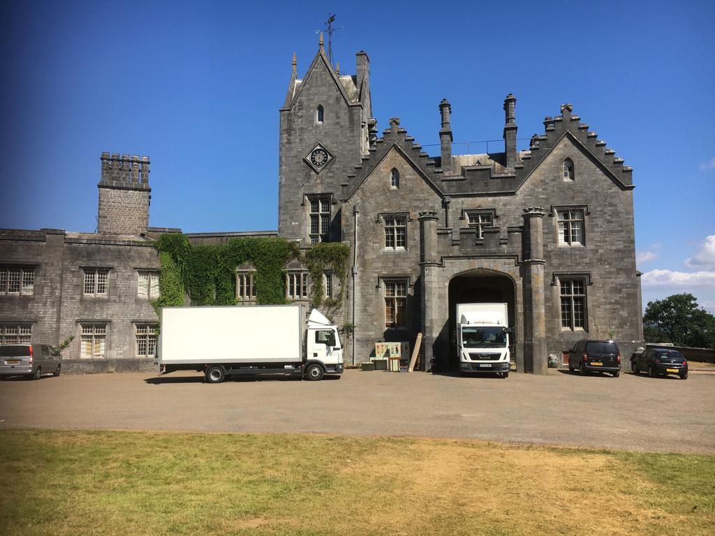 two white core lorry's in front of a stately home