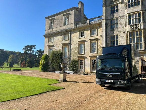 a black core lorry in front of a stately home