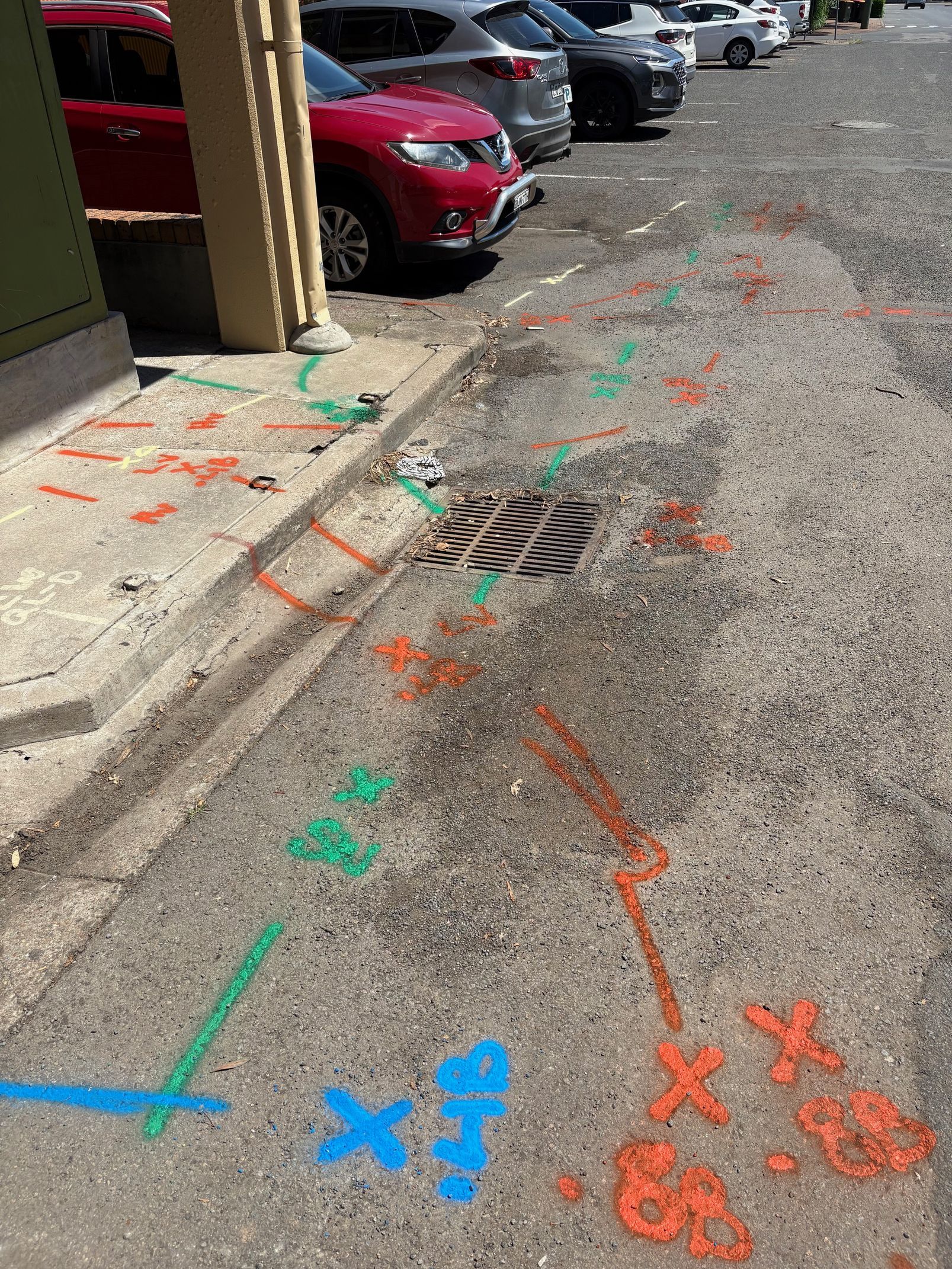 A row of cars are parked on the side of the road.
