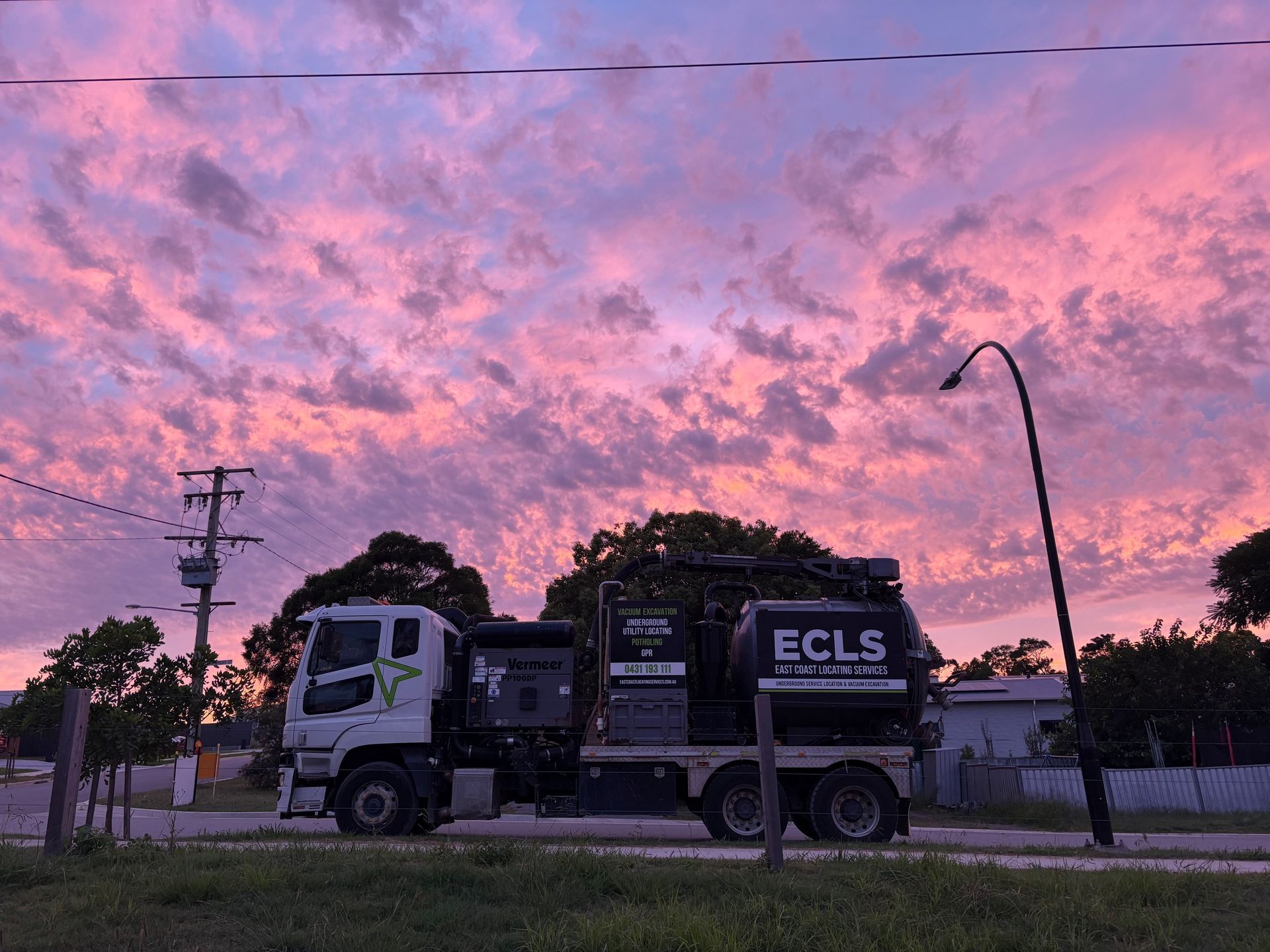 A Row Of Trucks Are Parked On The Side Of The Road — East Coast Locating Services In Wallalong, NSW