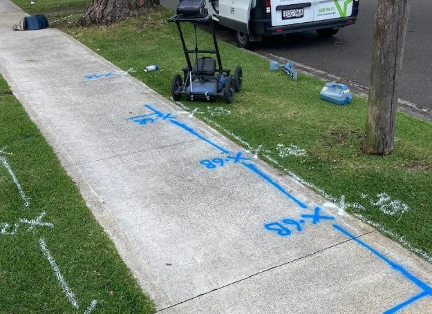 A Lawn Mower Is Sitting On The Sidewalk Next To A White Van — East Coast Locating Services In Wallalong, NSW