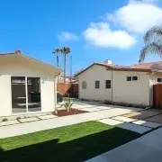A white detached ADU with a large sliding glass door in the backyard. Huntington Beach ADU.