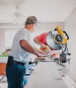 Craftsman cutting a board with a table saw in a kitchen remodel Huntington Beach CA