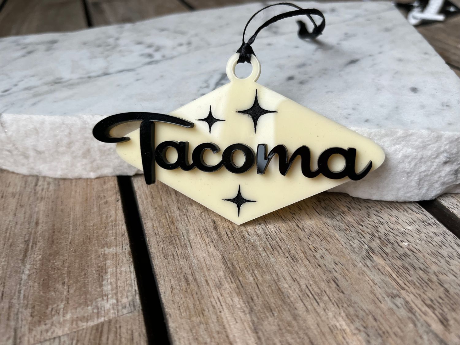 A tacoma air freshener is sitting on a wooden table