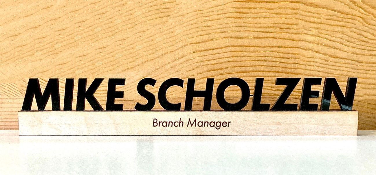 A wooden sign that says mike scholzen branch manager