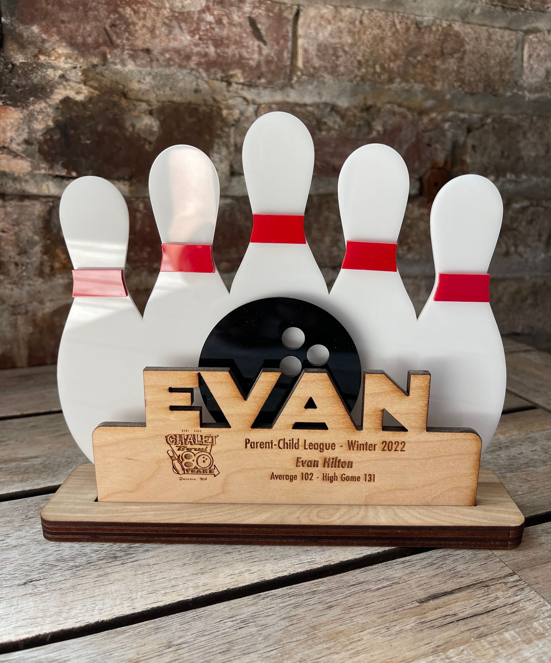 A bowling pin holder with the name evan on it