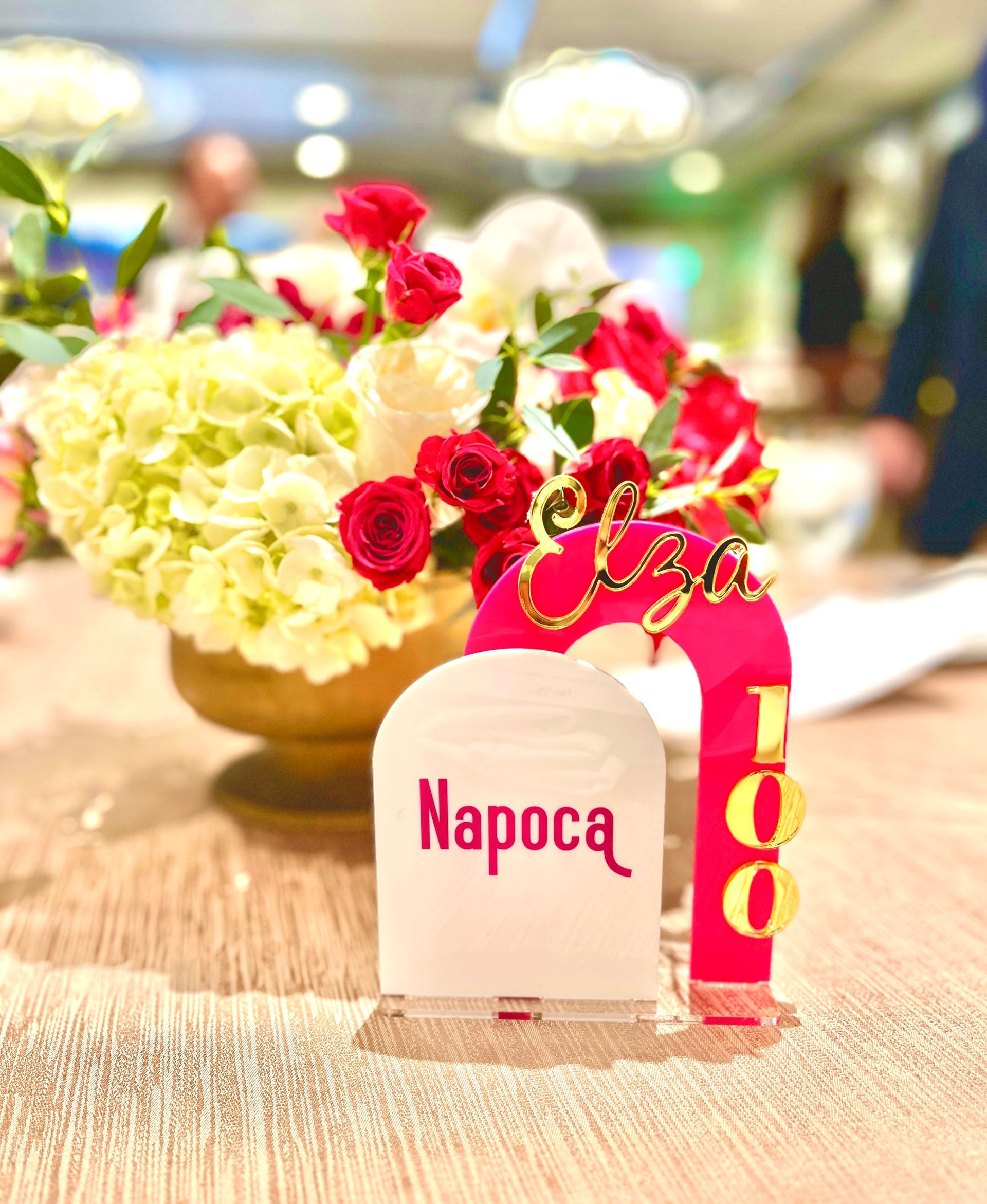 A table with a vase of flowers and a table number.