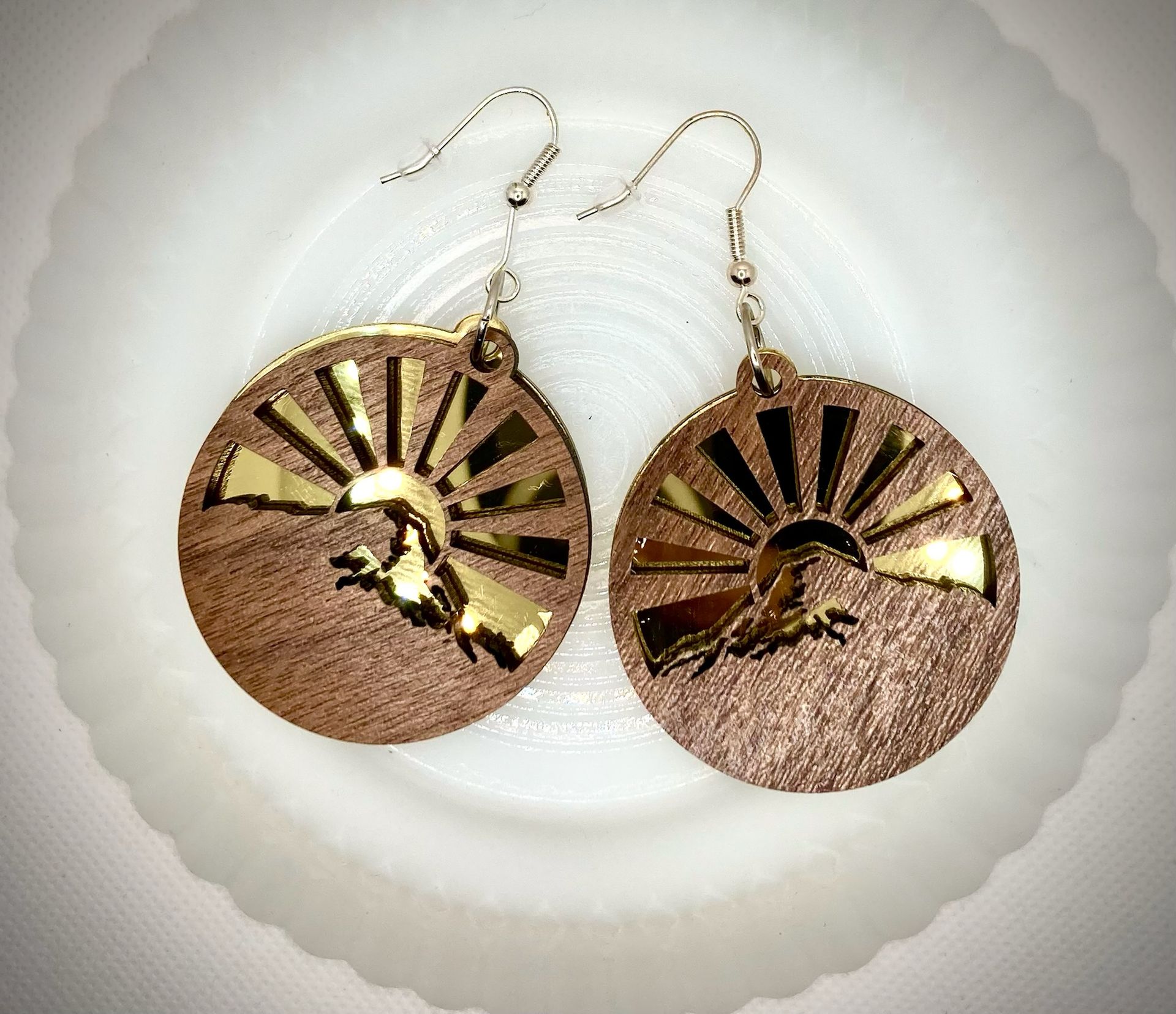 A pair of earrings are sitting on a white plate.