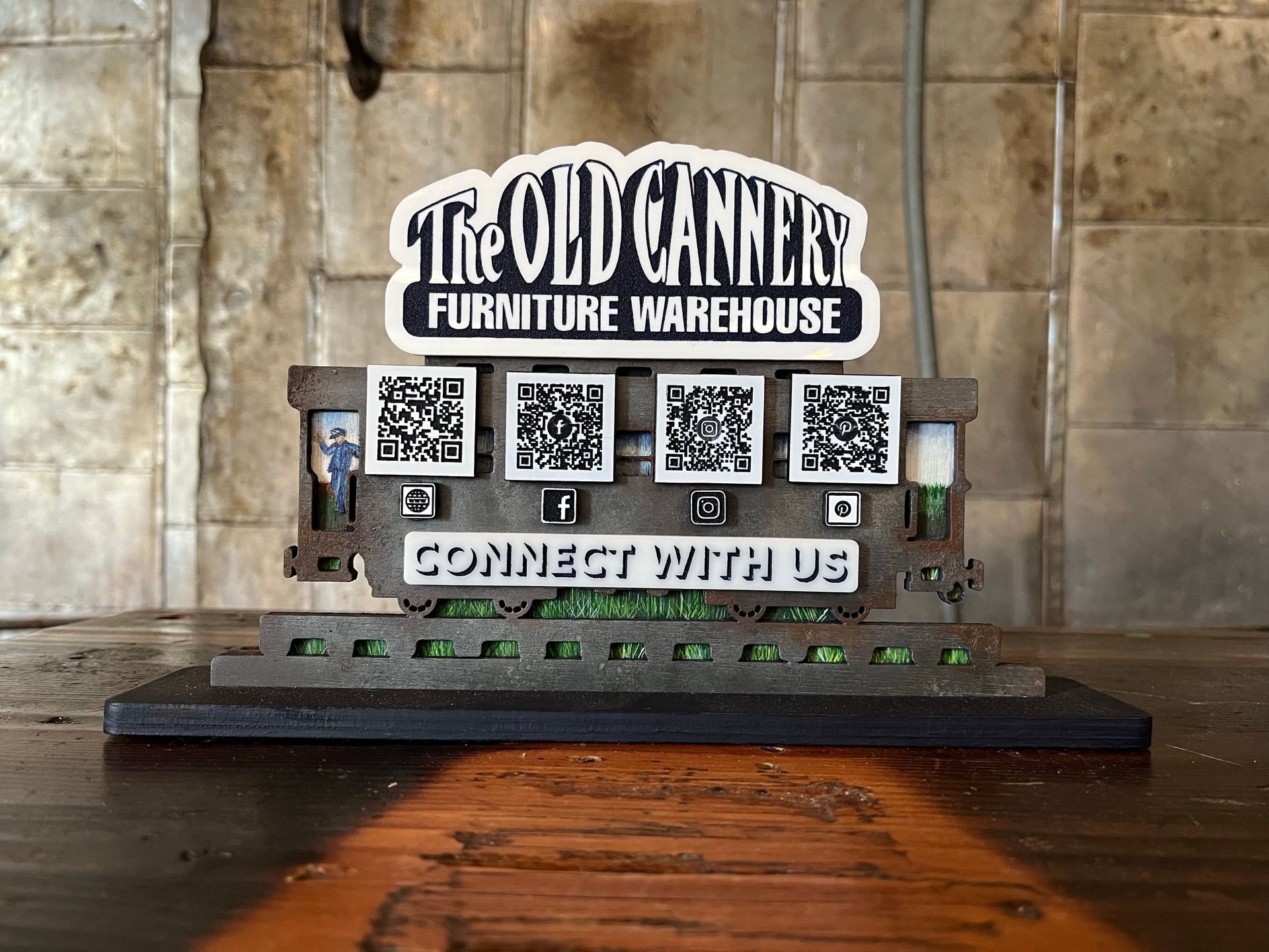 A sign for the old cannery's furniture warehouse is sitting on a wooden table.
