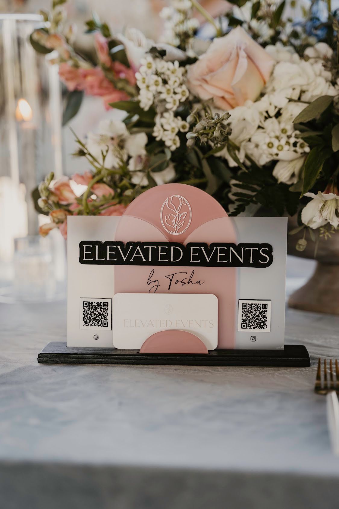 A table with flowers and a sign that says elevated events on it.