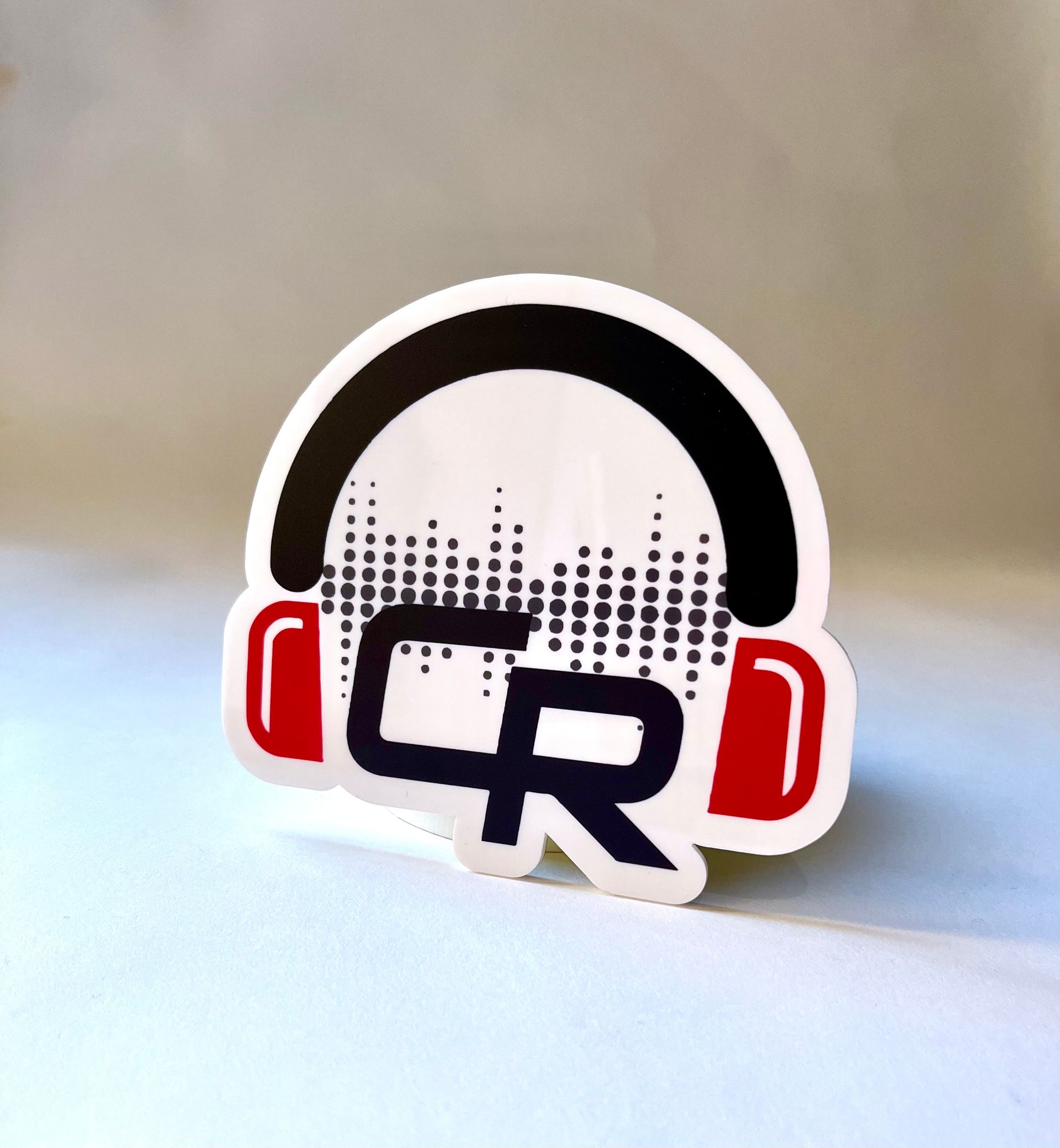 A sticker with headphones and the letter cr on it