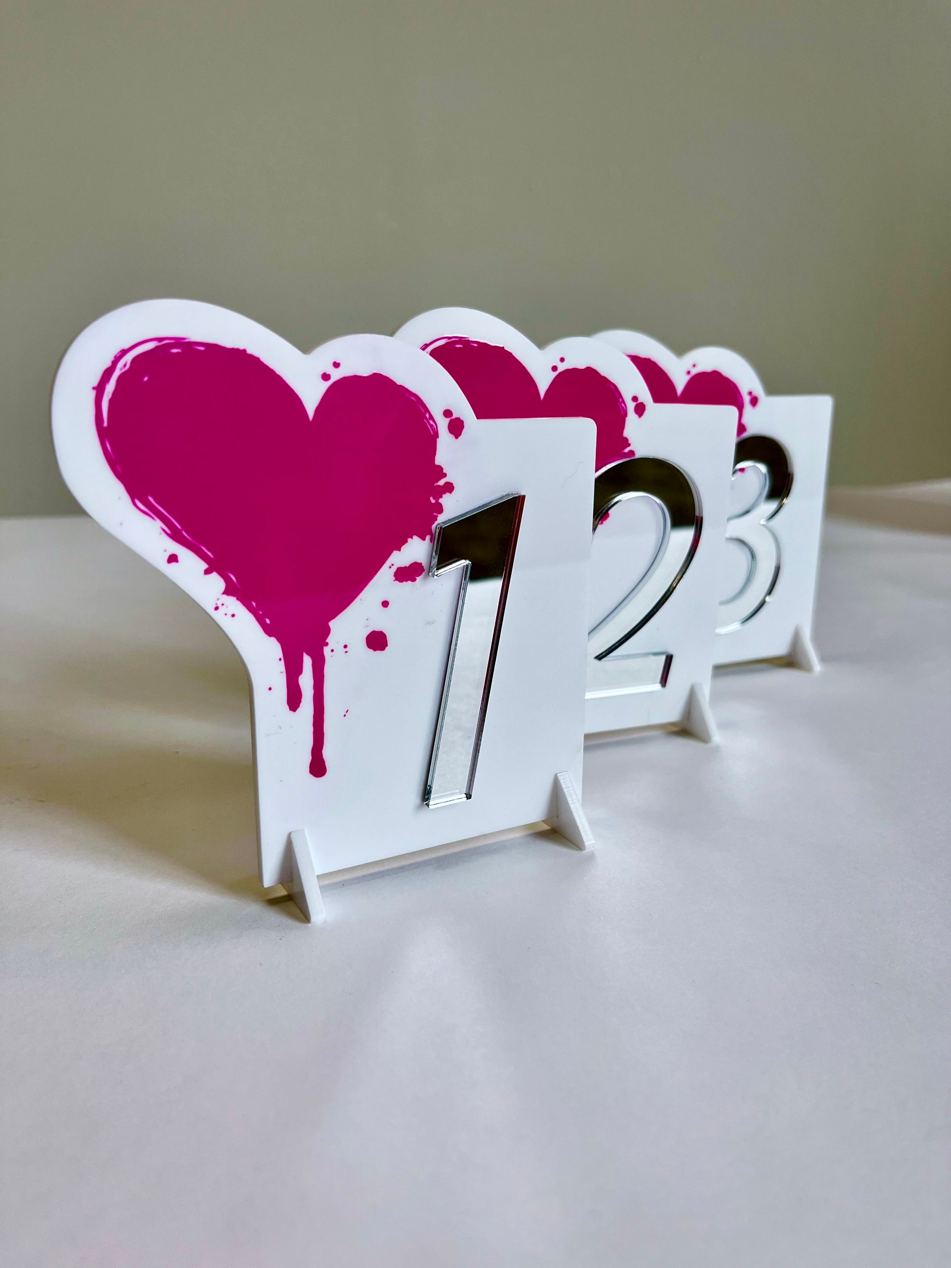 A row of table numbers with pink hearts on them