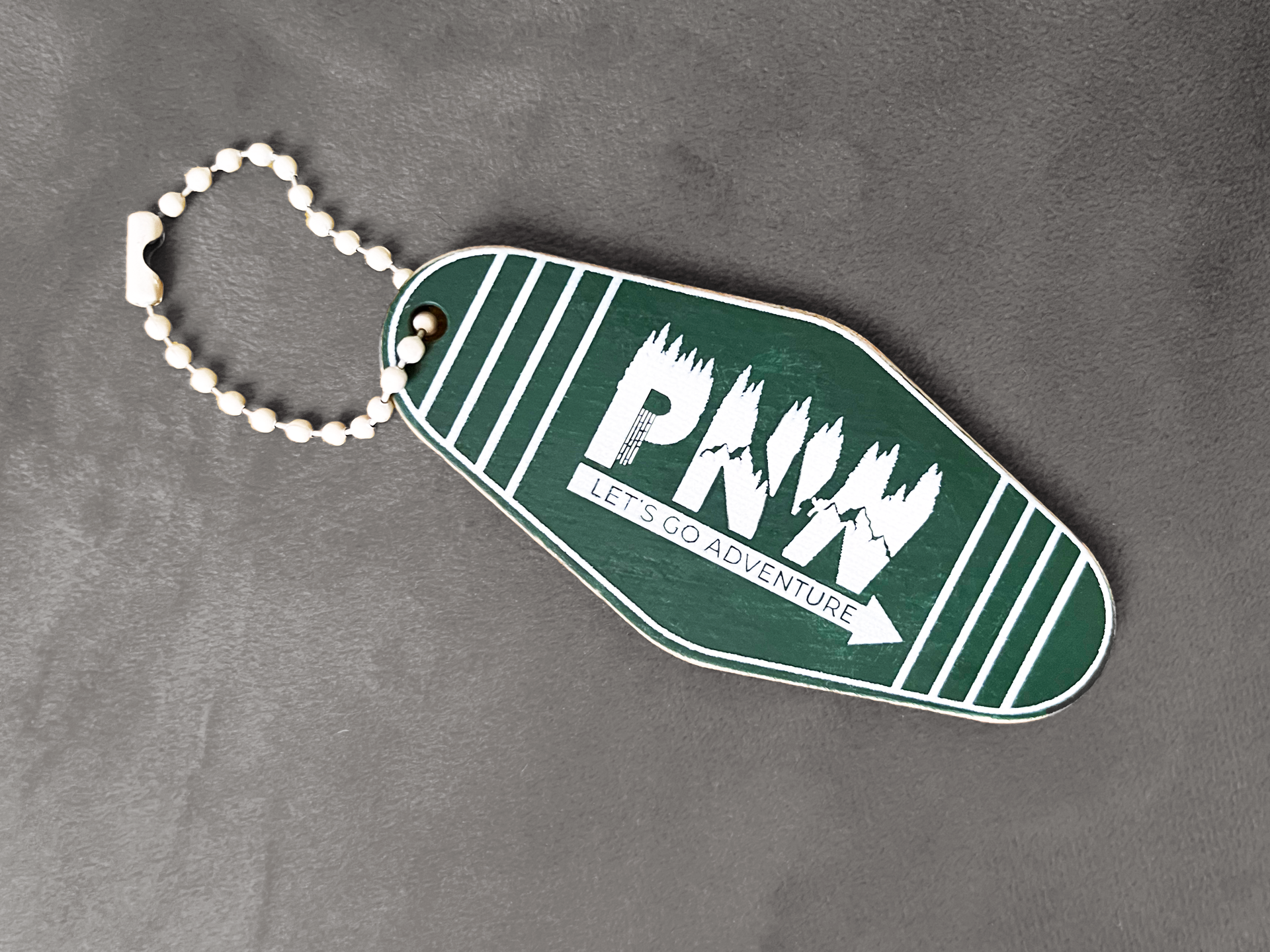 A green keychain with the word pnw on it