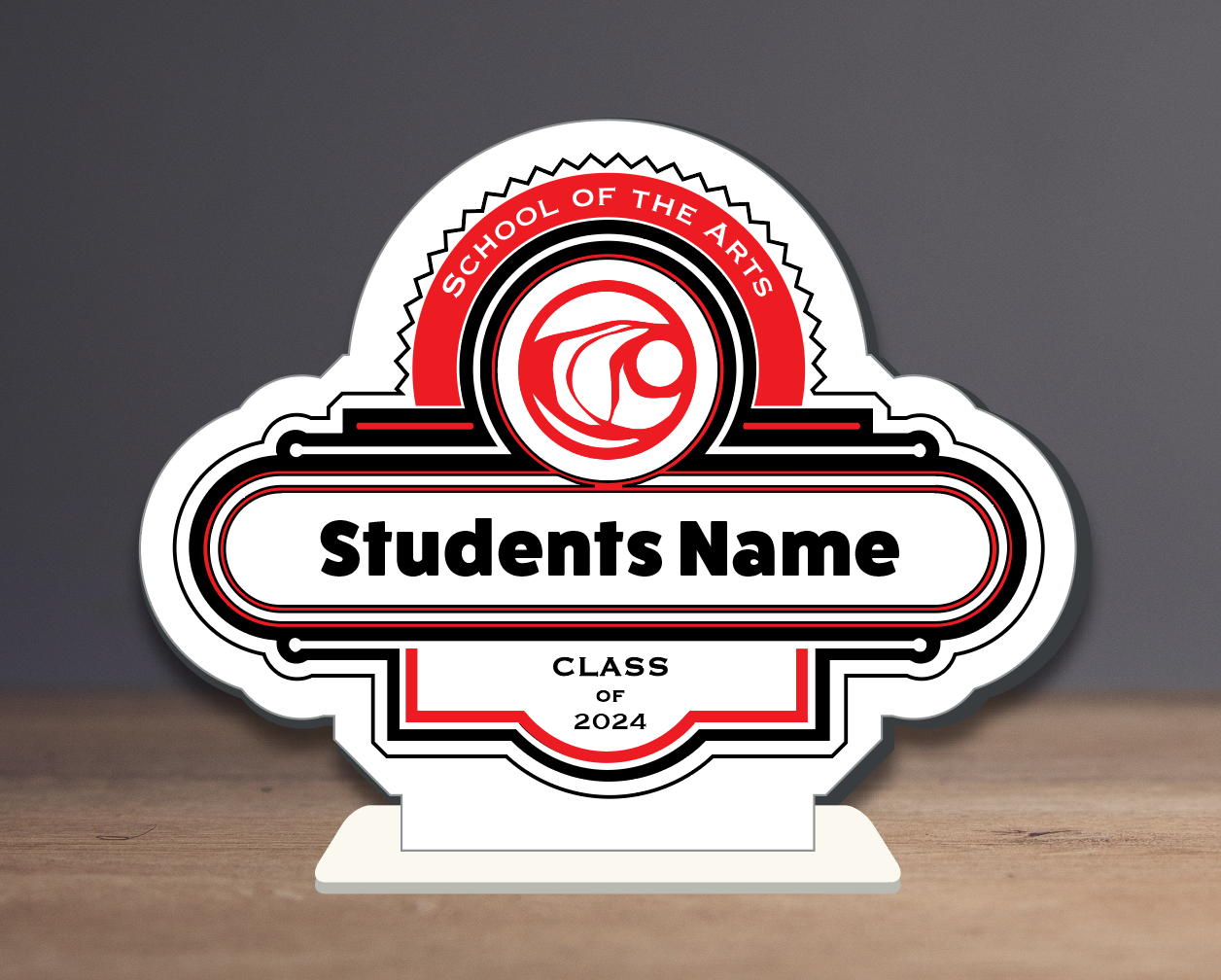 A sign that says students name is sitting on a wooden table.