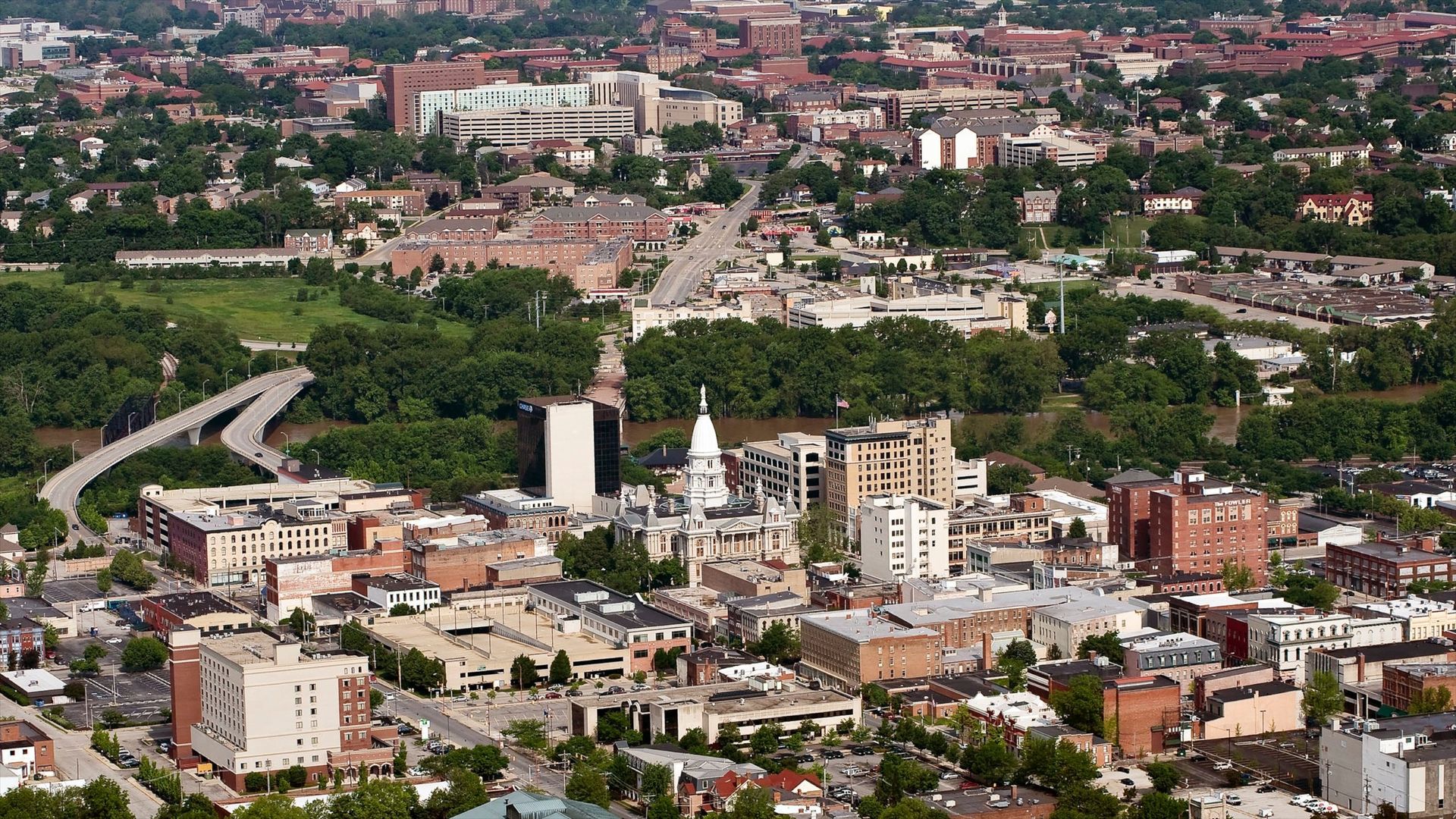 Aerial view of Springfield, Illinois, with buildings, roads, and a park, with the State Capitol building in the center.