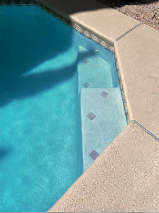 A close up of a swimming pool with blue water and steps.