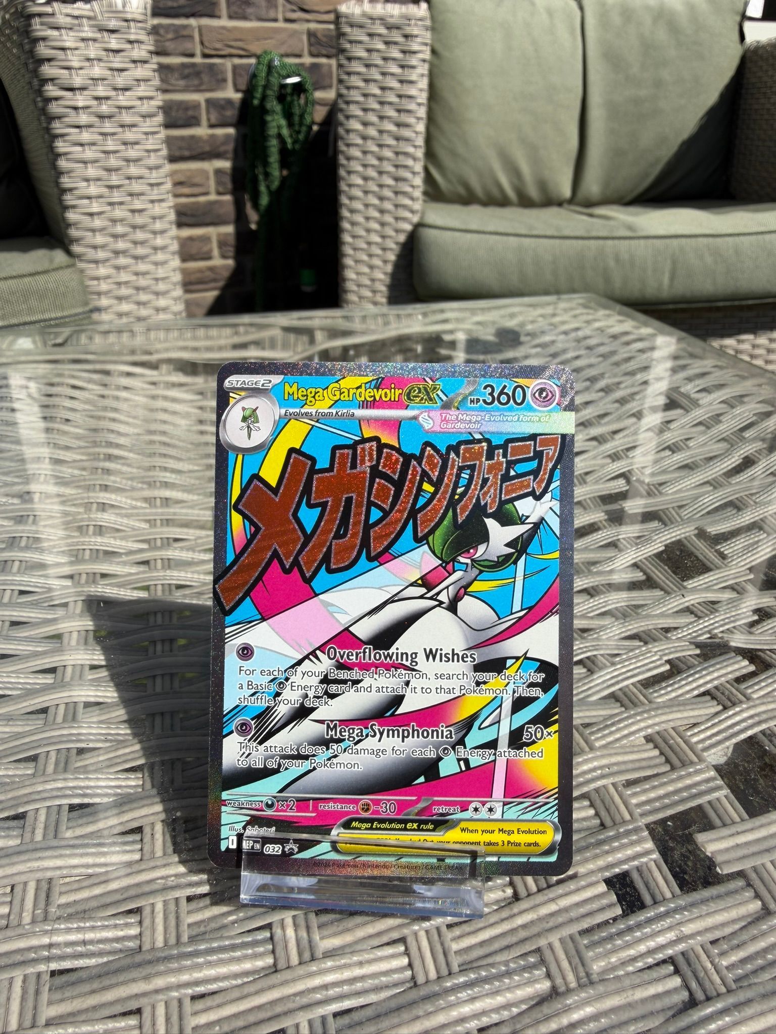 Mega Gardevoir EX Pokémon-kaart met Japanse tekst, roze-zwarte afbeeldingen en een regenboogachtergrond.