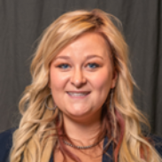 A woman is wearing a stethoscope around her neck and smiling.
