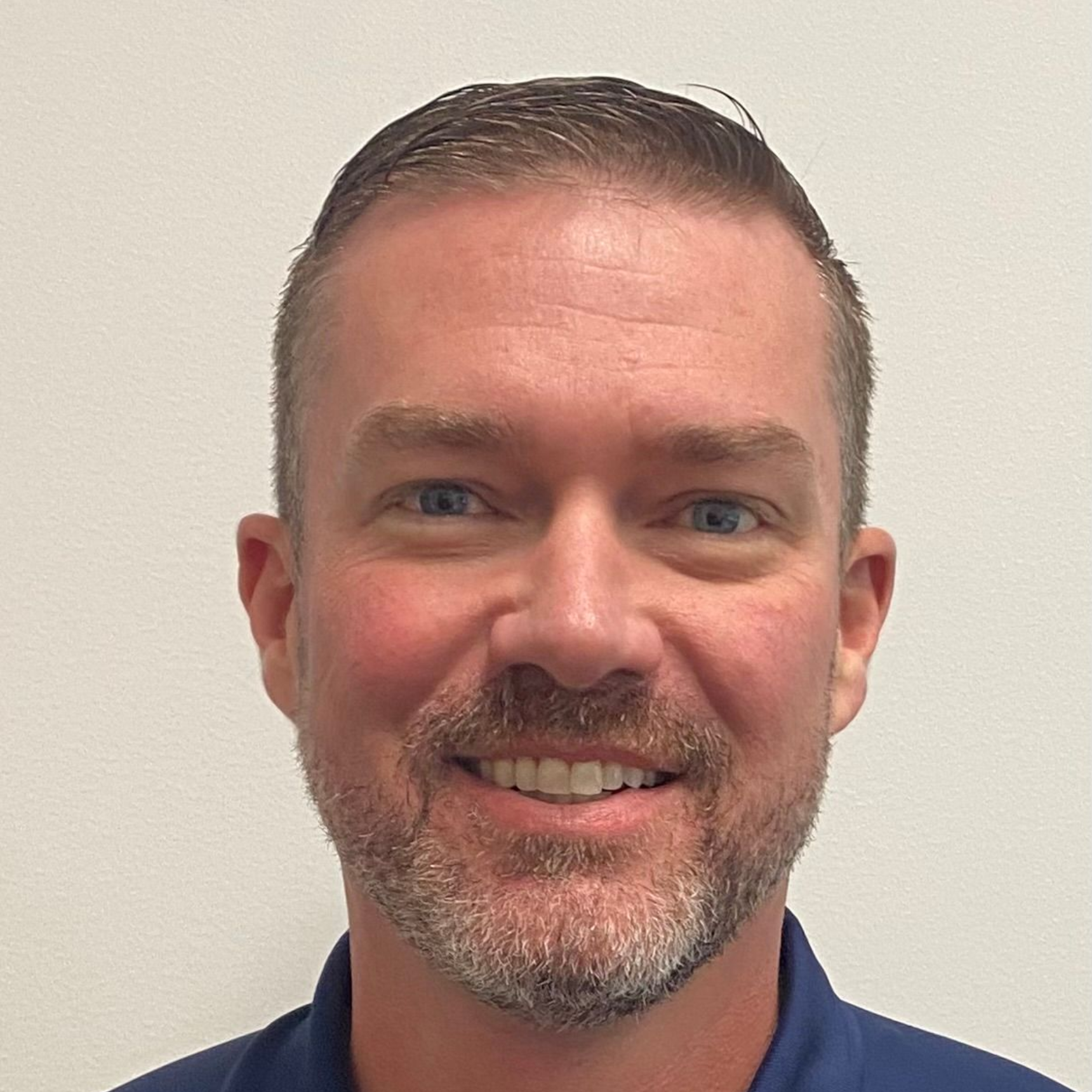 A man with a long beard and glasses is smiling for the camera.