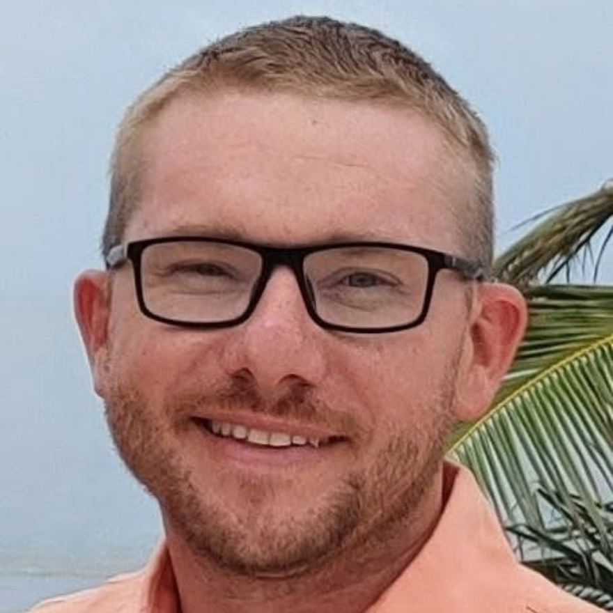 A woman is wearing a white lab coat and a yellow shirt.