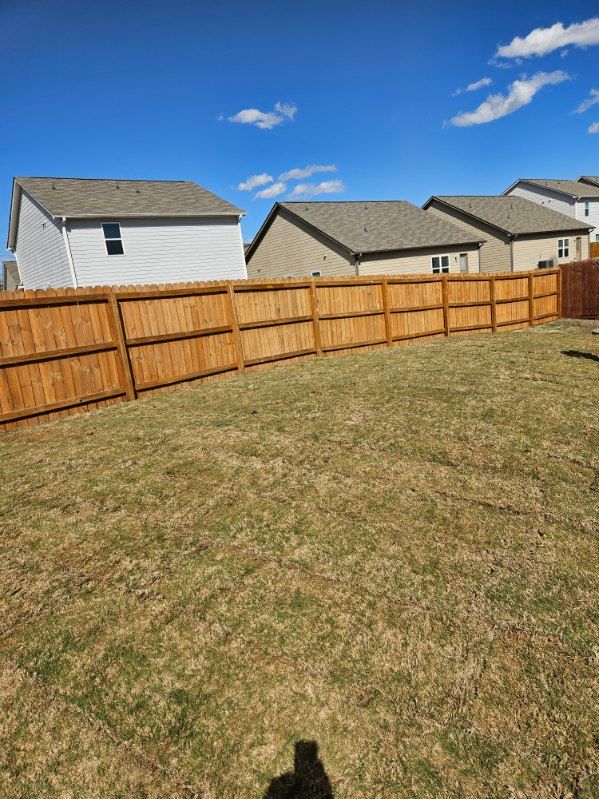 There is a wooden fence in the backyard of a house.