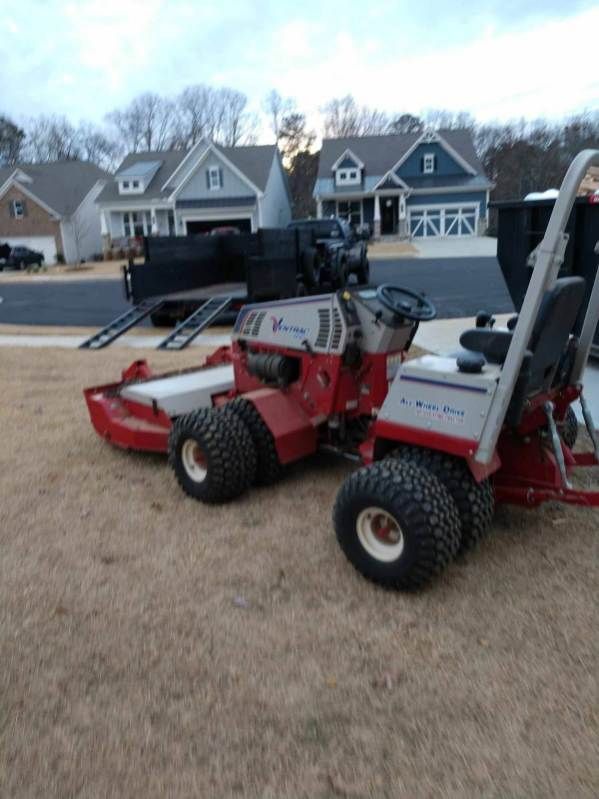 A red lawn mower is parked in front of a house