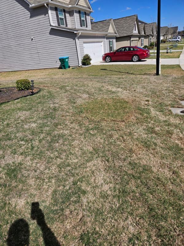 A red car is parked in front of a house in a residential area.