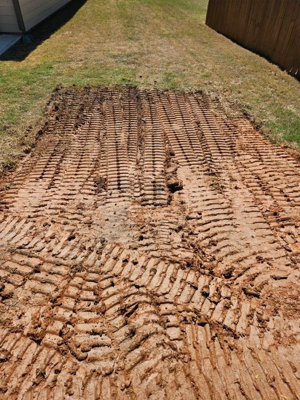 A large pile of dirt is sitting in the middle of a yard.