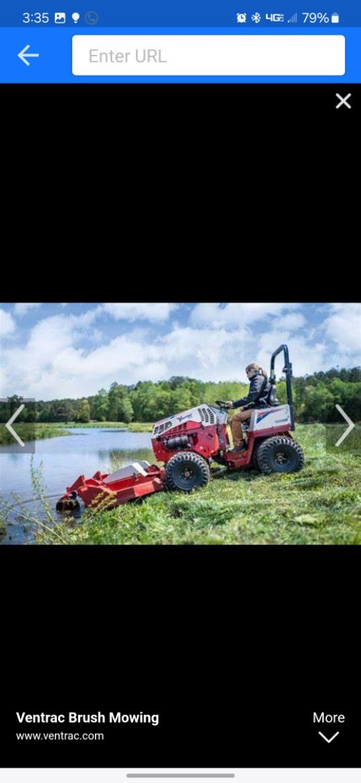 A man is riding a lawn mower in a field next to a body of water.