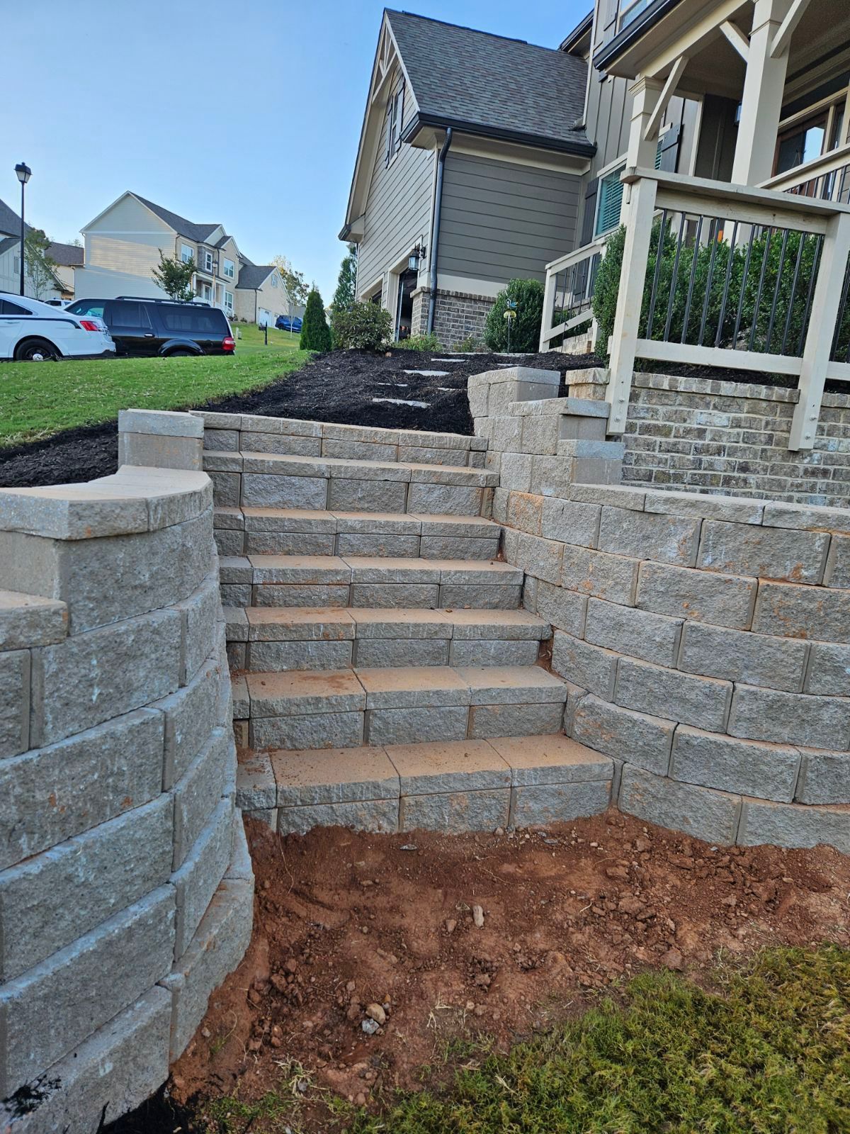 A set of stone stairs leading up to a house in a residential area.