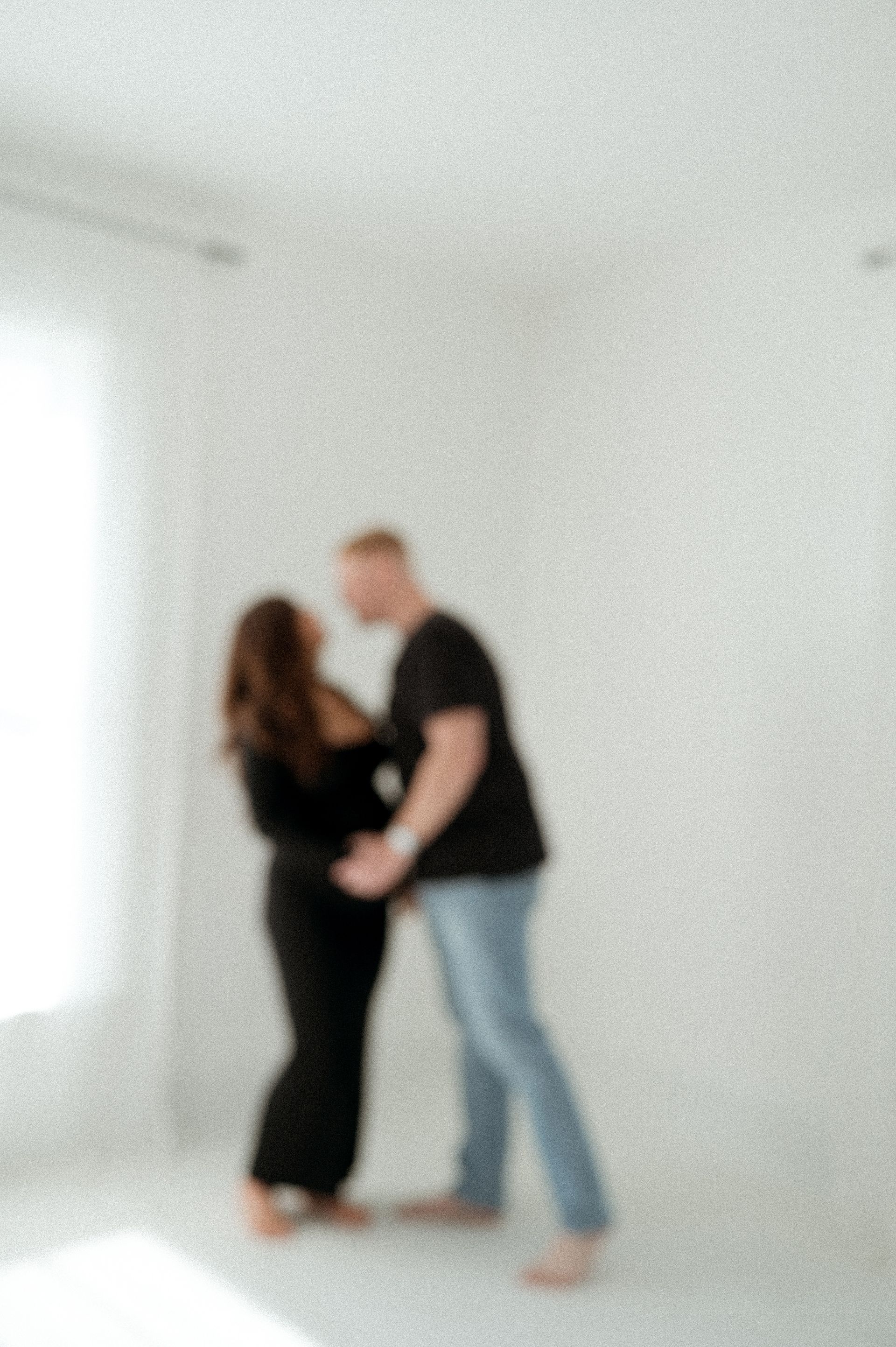 A blurry picture of a man and a woman standing next to each other in a room.