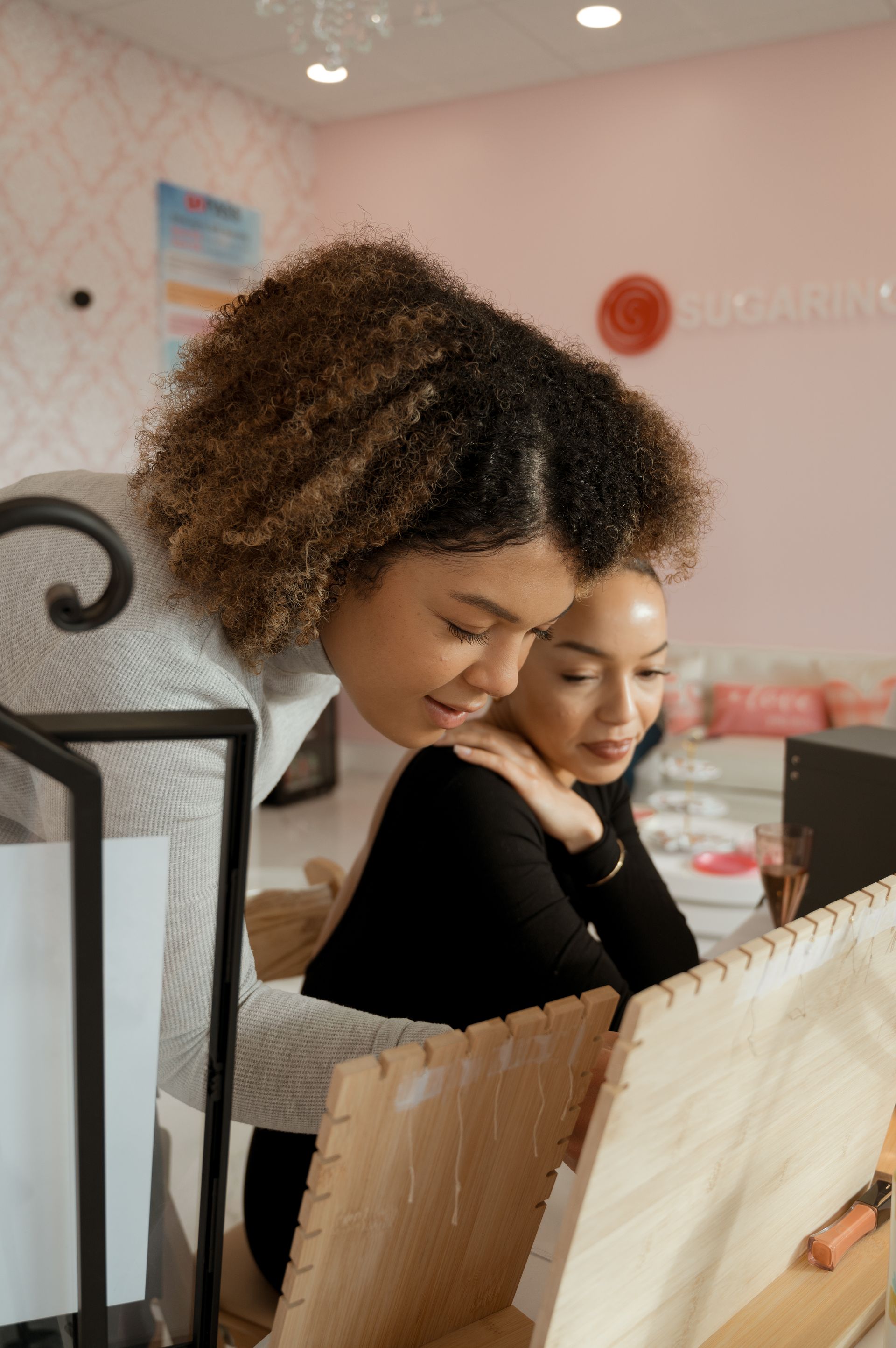Two women are looking at a display of jewelry in a store.